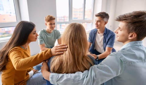 group of teenagers sitting in a circle expressing comfort and support to battle suicide and depression